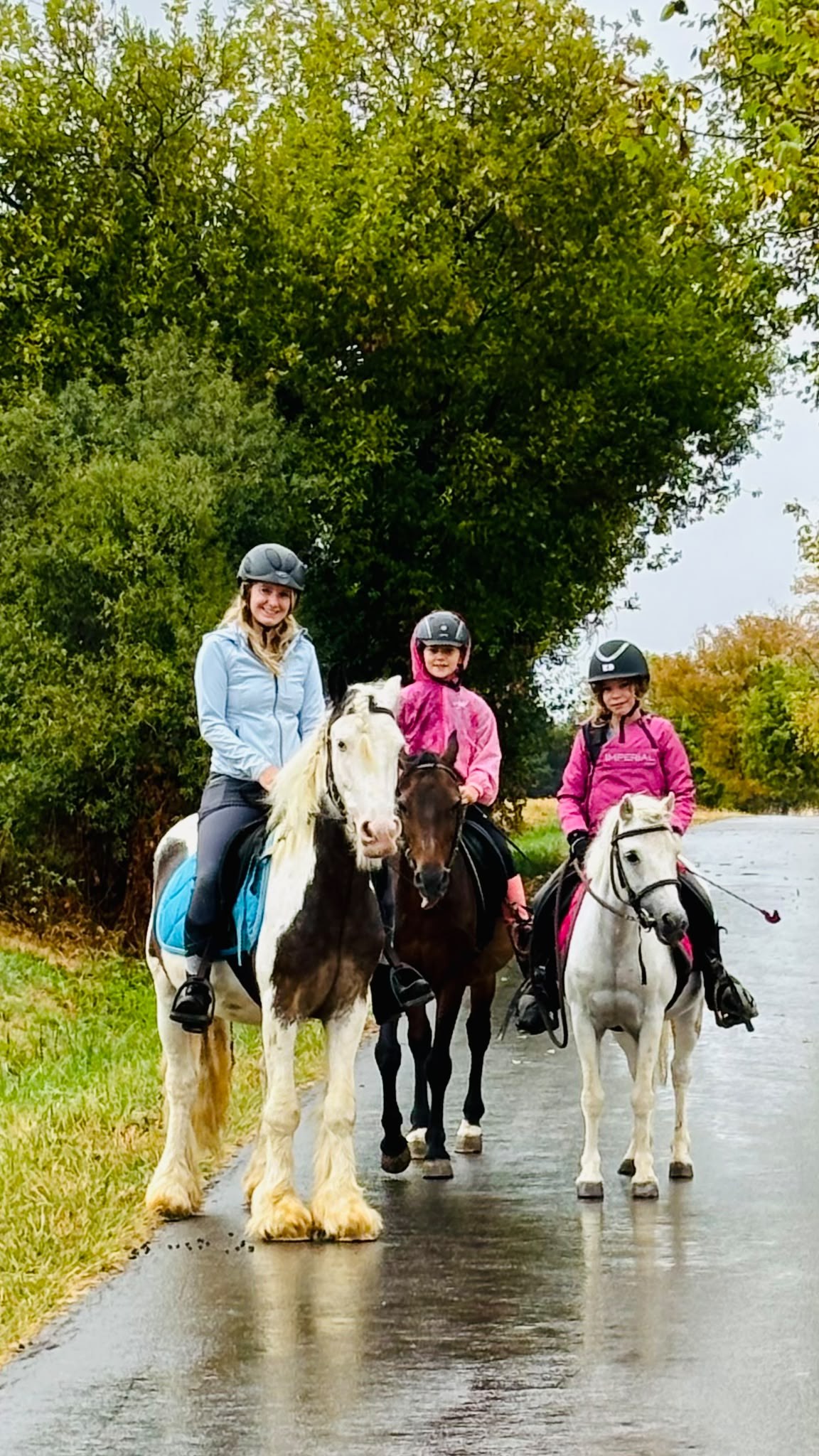 Three riders with ponies outdoors